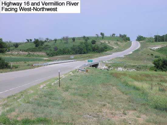 highway bridge over Vermillion River; road flat at bridge; rises to hill in background