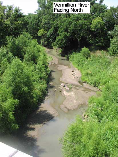 View of Vermillion River from bridge; some water with wet sandy creek bed; large trees downstream