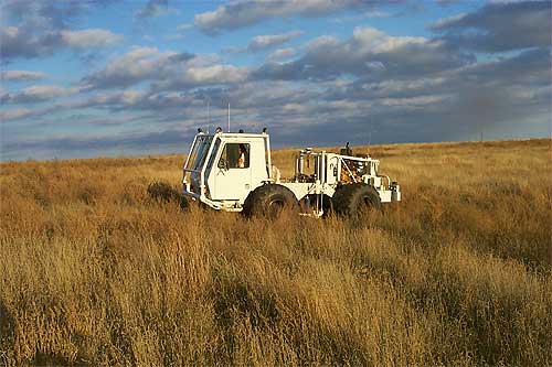Minivib2 seismic source vehicle in tall, brown grasses