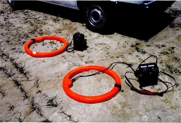 Two orange rings connected to small black control boxes. Each ring is similar in diameter to a car or truck tire and 2 inches or so thick.