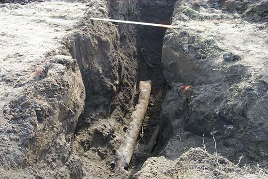 buried steel pipes uncovered by backhoe