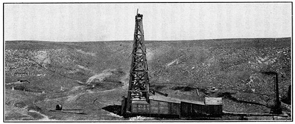 Black and white photo of chalky limestone of the Jetmore member of the Greenhorn limestone, wooden drilling rig in foreground.