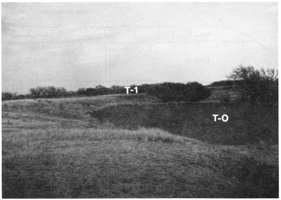 Black and white photo of scarp separating the T-1 and T-0 surfaces at locality PR-7.