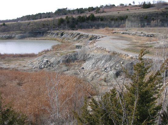 The broad, flat surface in the center of the photo is the top of the Glenrock Limestone Member of the Red Eagle Limestone and the Carboniferous-Permian boundary at Tuttle Creek Lake Spillway in Pottawatomie County, Kansas.