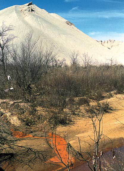 Bright orange water flowing from waste pile into creek.