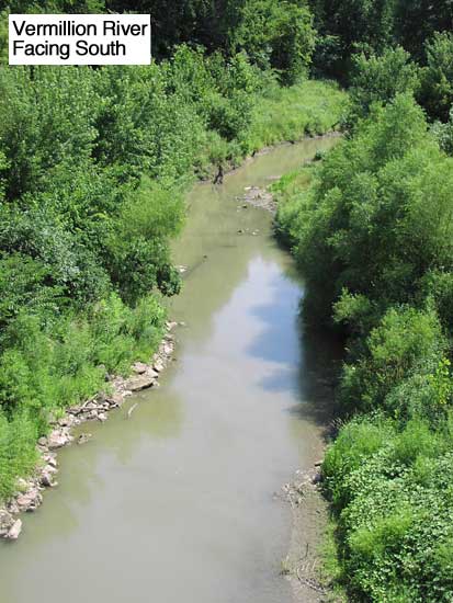View of Vermillion River from bridge; some water with wet sandy creek bed; large trees downstream