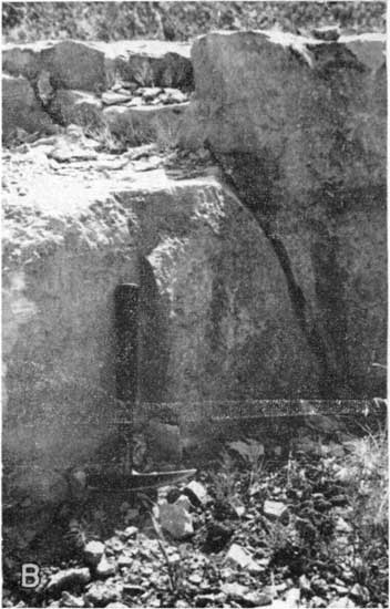 Black and white photo of large black of Crouse limestone; rock hammer for scale.
