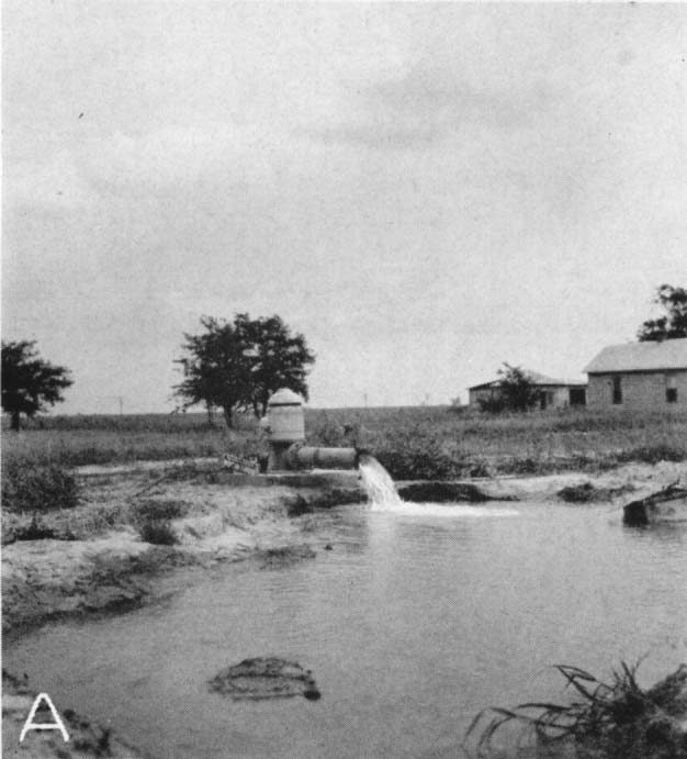 Black and white photo of pump with water flowing into holding pond.