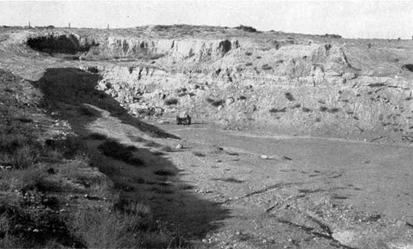 Black and white photo of large gravel pit, 80-90 feet deep.