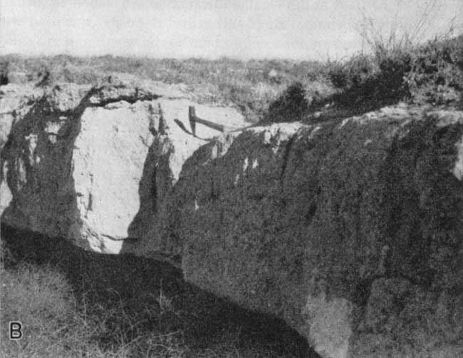 Black and white photo of resistant bed, 3 or more feet thick; rock hammer for scale.