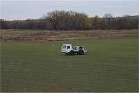 Vibraseis truck in field showing green winter wheat emerging