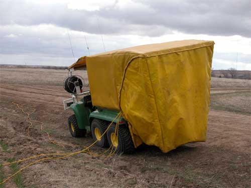 Green ATV with yellow cover over work area