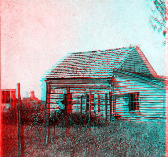 small log cabin; windmill in background