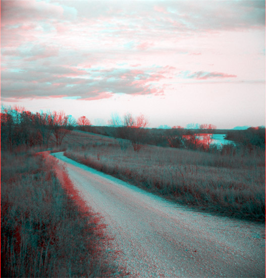 gravel road on grass-covered small bluff above river