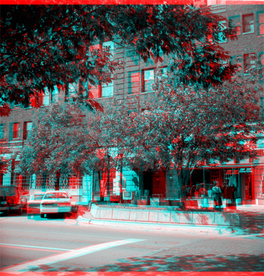 1990s Photo of 5-story brick-faced hotel; limestone on first floor; trees and street planters