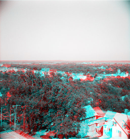 Lawrence from small hill; many trees; downtown business district with clocktower of courthoise in center of photo