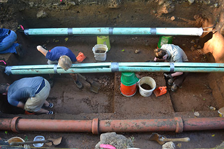 Odyssey crews excavating Paleoindian occupation layer beneath modern utility lines.