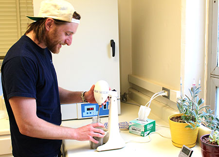 Researcher Kevin Fenyak mixing soil and water with a mixer.
