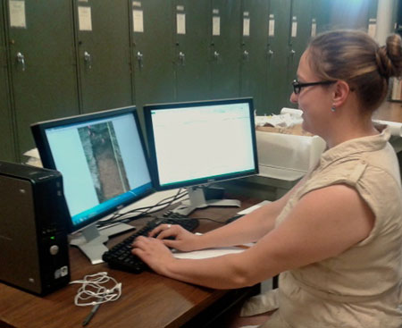 Researcher Anna Wieser at computer workstation entering soil profile data.