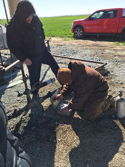 Berexco field crew conducting a fluid level measurement test with an echometer at wellington unit #61.