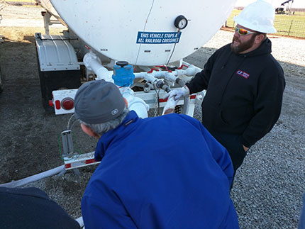 Photo of Jason Bruns, field operations with Berexco, looking at back of storage tanks.