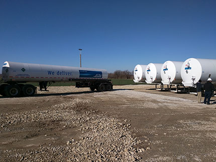 Shows a delivery truck from Woodward, OK, backing up to the left storage tank.