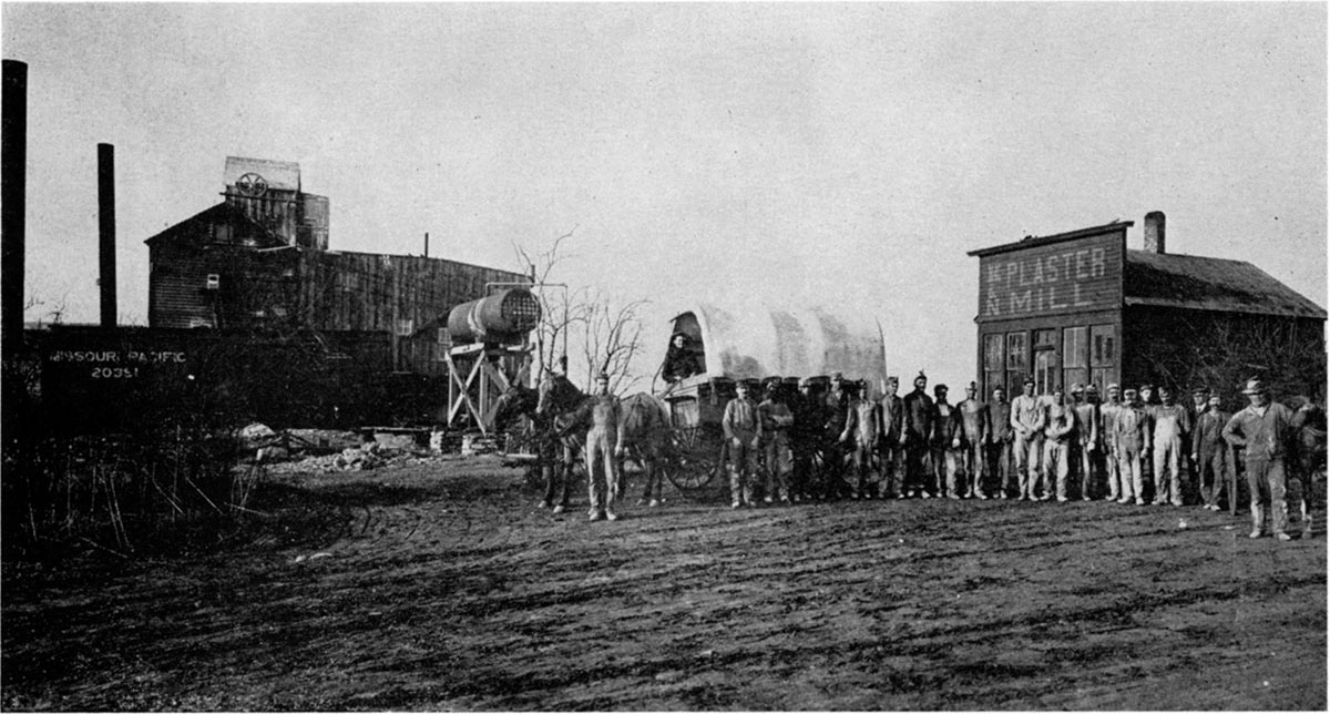 Black and white photo; Headframe, office, and employees of old Hope mine.