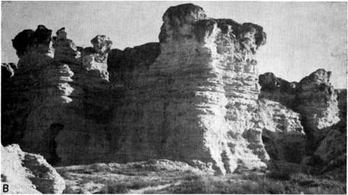 Black and white photo; steep cliffs of white chalk, rising above flat surrounding landscape.