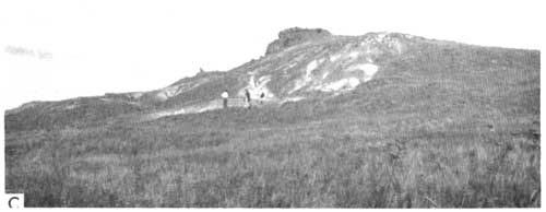 Black and white photo of outcrop; small hill with several people observing.