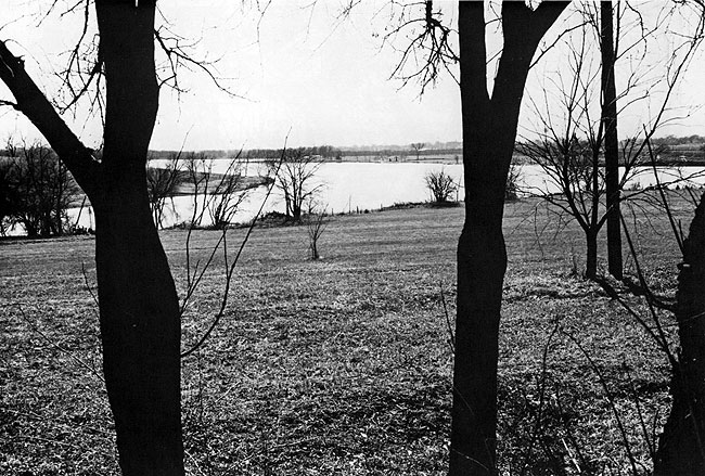 Photo of Mission Lake, Horton, Kansas; grass covered slope toward lake, a few trees.