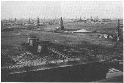 old black and white photo of 50-100 oil derricks