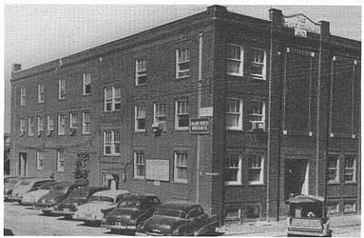 black and white photo of three-story brick building