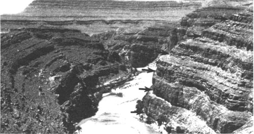 Black and white photo of steeply sided stream channel, clear stair-step look to canyon walls.