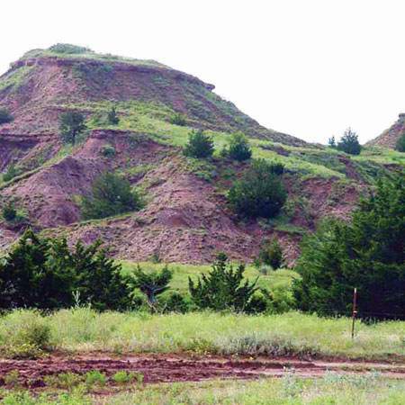 Color photo, hill with exposures of Cedar Hills Sandstone.