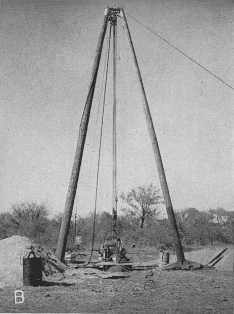 Black and white photo showing construction of well.