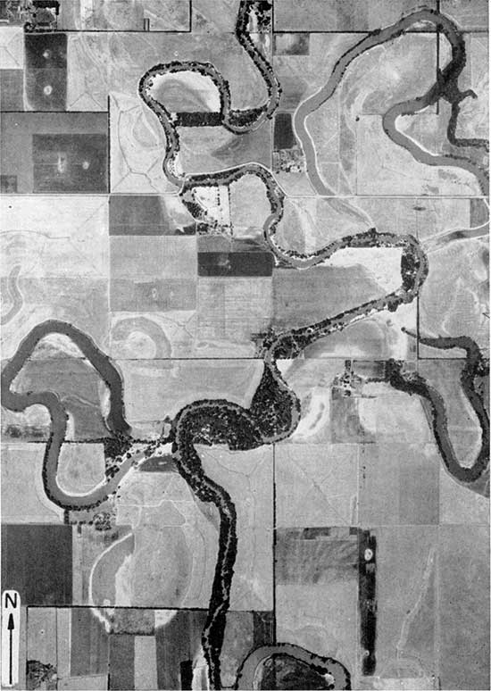 Black and white aerial photo of Smoky Hill River shows extreme meandering, old meanders showing up in cultivated fields, and cut-off lakes.