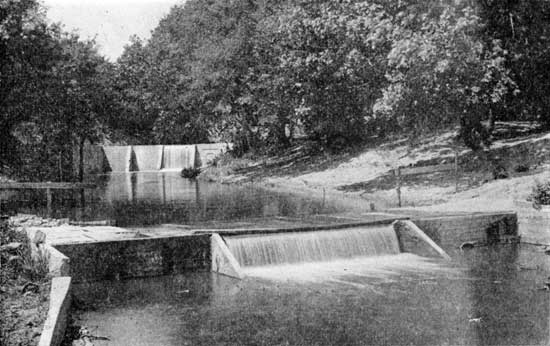 Black and white photo of water flowing over Moffet Dam on Pawnee River.
