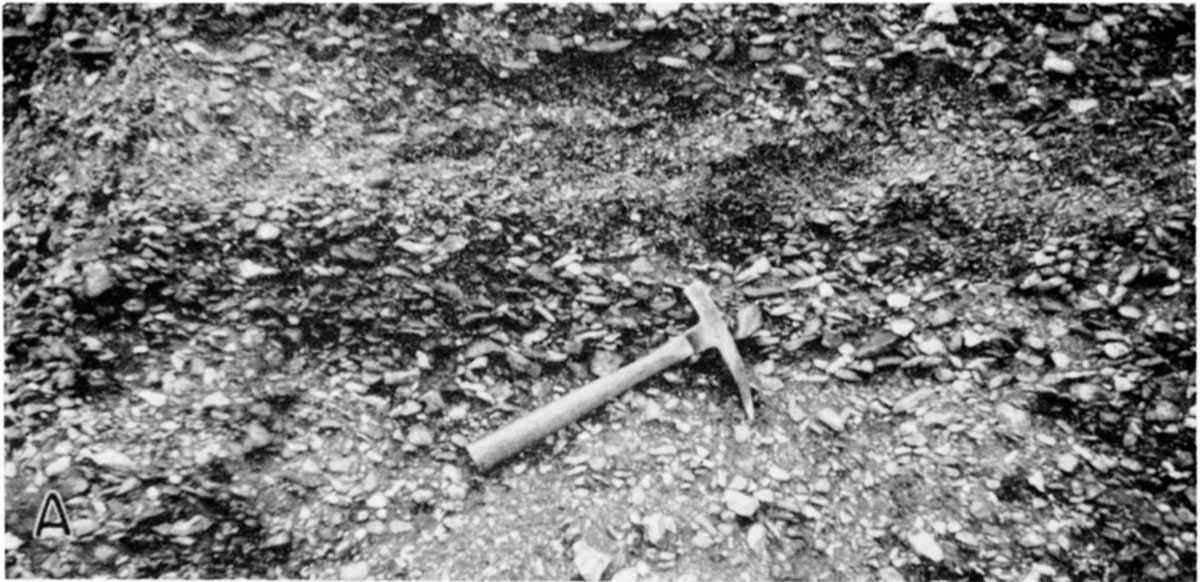 black and white photo of gravels, rock hammer for scale