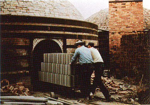 Raw tile being wheeled into a kiln for firing.