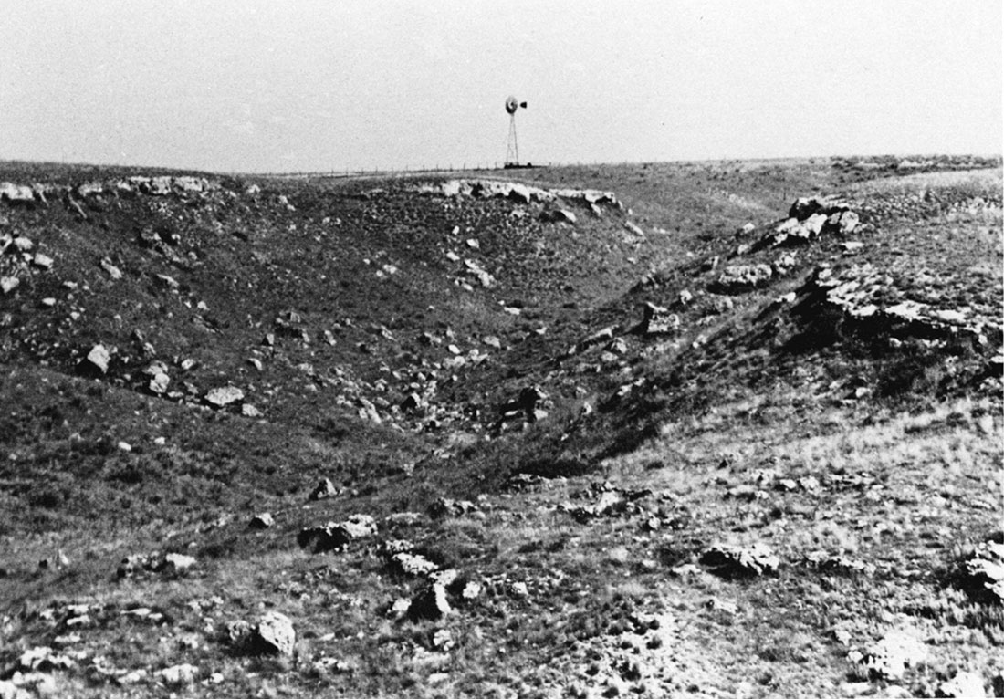 Black and white photo of outcrops of silicified material of the Ogallala Formation along the northern edge of Big Basin, Clark County.