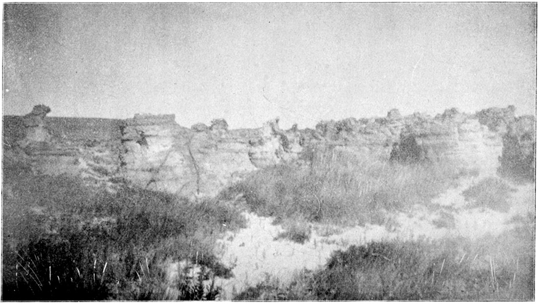 Black and white photo: Eroded ledge of Cheyenne Sandstone in Hell's-Half-Acre, western side, Barber County.