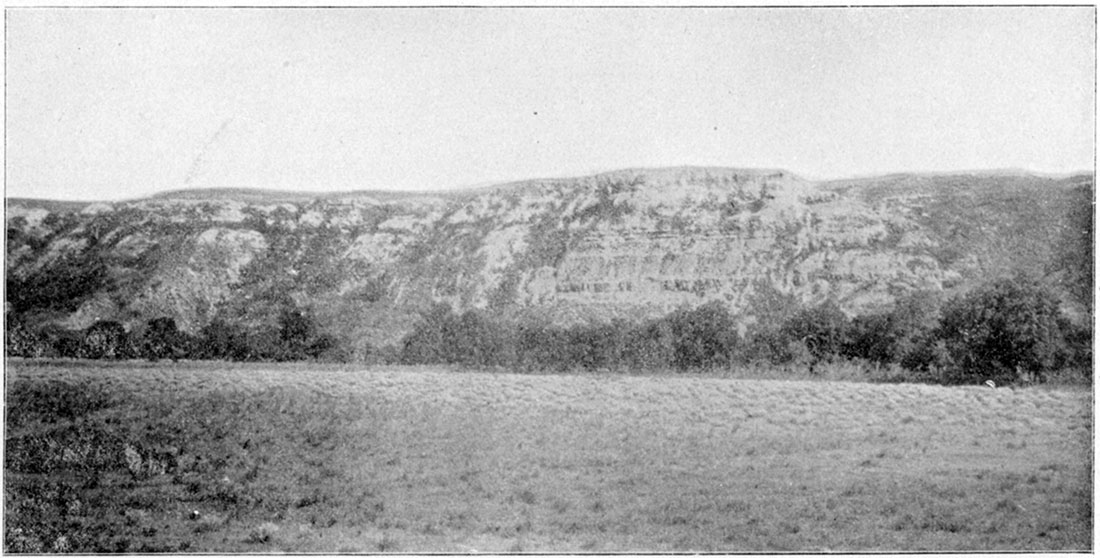 Black and white photo: Cliff at the entrance of the amphitheater on Bluff Creek, fifteen miles north of Ashland, Clark County.