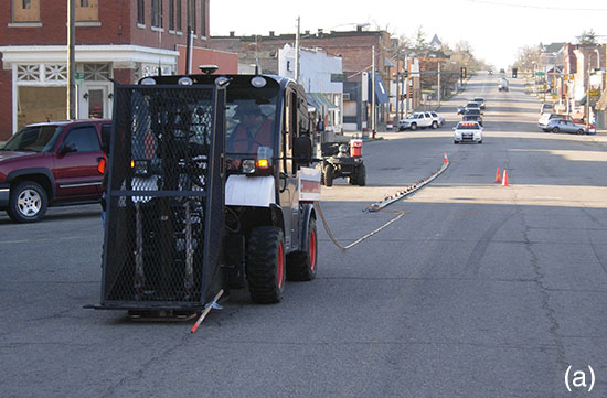 Two color photos; top is of weight drop attached to Bobcat, on street in Galena.