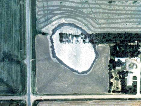 Aerial photo shows roughly circular hole filled with water.