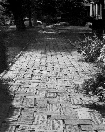 Black and white photo of bricks made of clay paving a sidewalk in Lawrence.